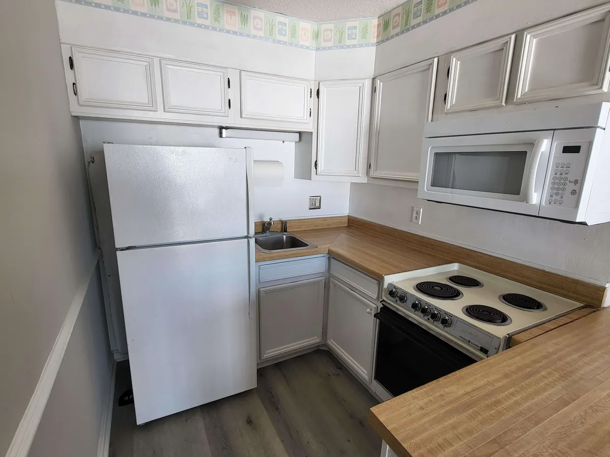 A practical and inviting kitchen space is on display, featuring a refrigerator, kitchen counter, stove, microwave, and sink. The layout emphasizes meal preparation, cooking, and the potential for entertaining guests or gathering as a family.